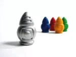ricochet robots Figurine grise devant quatre objets colorés bleu rouge orange vert